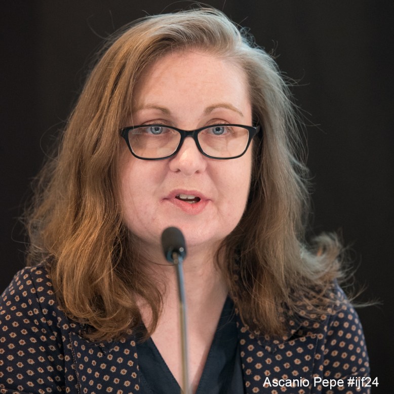 Maria wearning a navy top speaking into a microphone